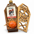 Ataúd de madera abierto con la botella de 250 ml de Tío Meke Frutas de Altar y Cempasúchil y una vela de cempasúchil naranja