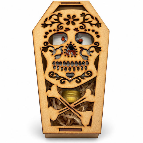 Ataúd de madera cerrado, con la calavera de azúcar calada a láser en la tapa