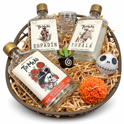 Arcón redondo con tres botellas de 250 ml de Tío Meke —Espadín, Tobalá y Frutas de Altar y Cempasúchil—, caballito calavera, vela de cempasúchil y figuras decorativas