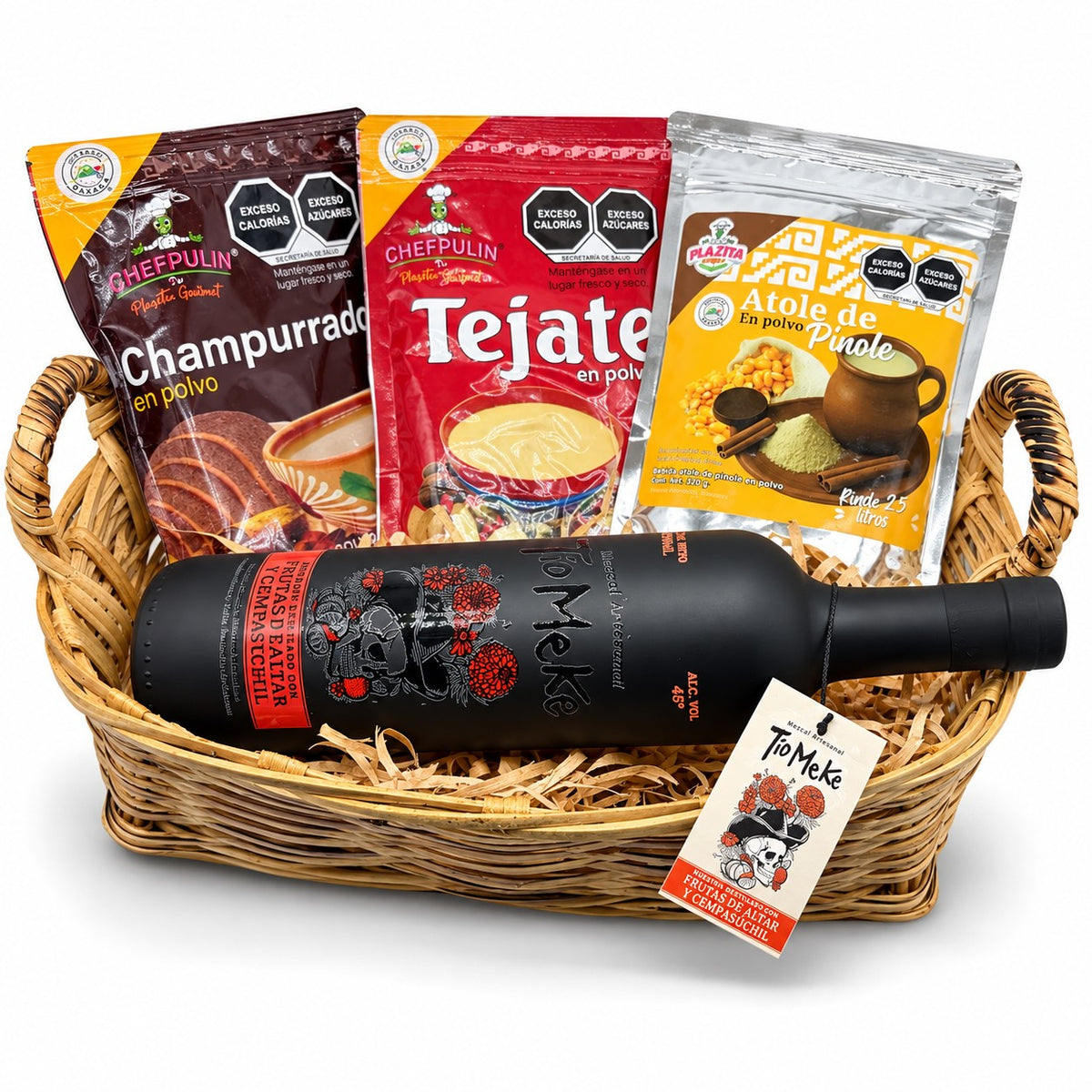 Canasta de mimbre con la botella negra de 750 ml de Tío Meke Frutas de Altar y Cempasúchil, champurrado, tejate y atole de pinole en polvo
